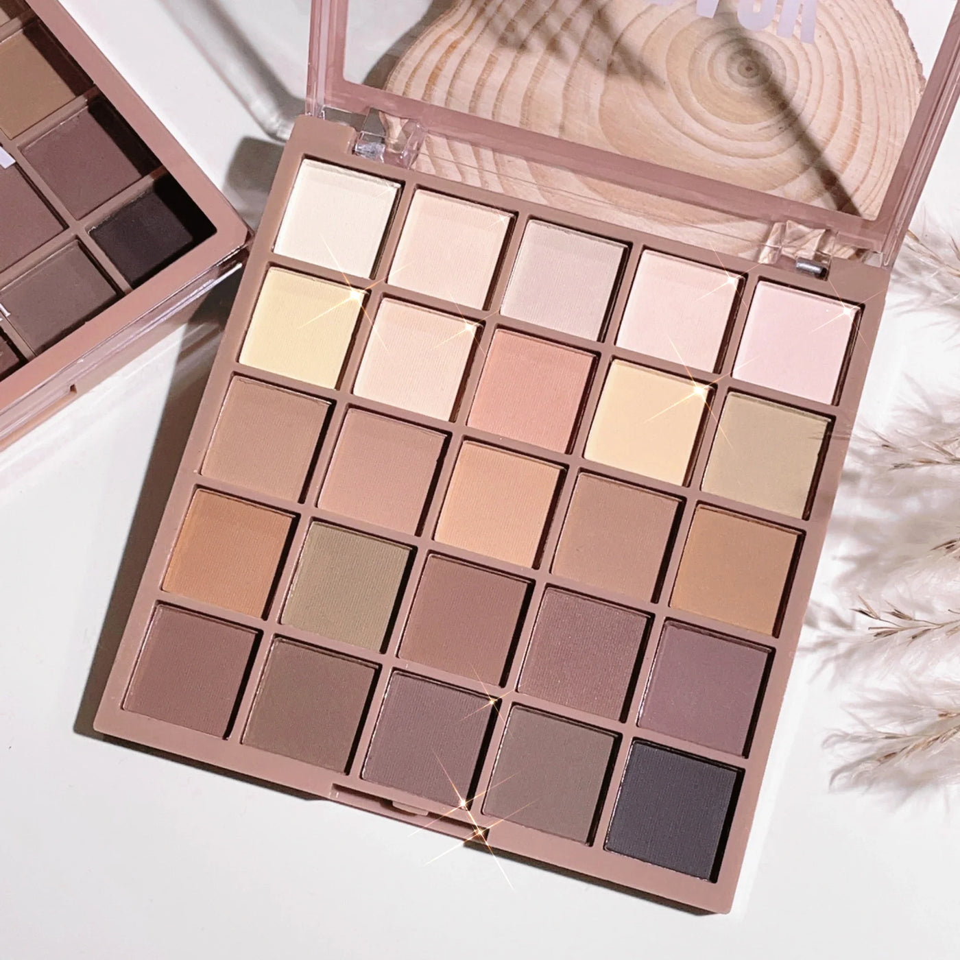 Palette de maquillage Glowease exposée sur une table, avec 25 nuances mates et satinées pour un maquillage du teint naturel et élégant.